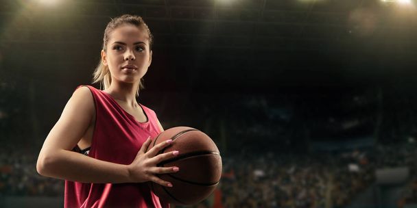 Jugadora de baloncesto femenina con balón en gran arena profesional
  - Foto, Imagen