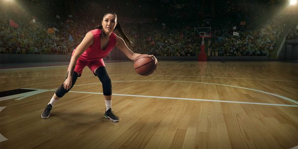 Giocatrice di basket femminile con palla su grande arena professionale
  - Foto, immagini