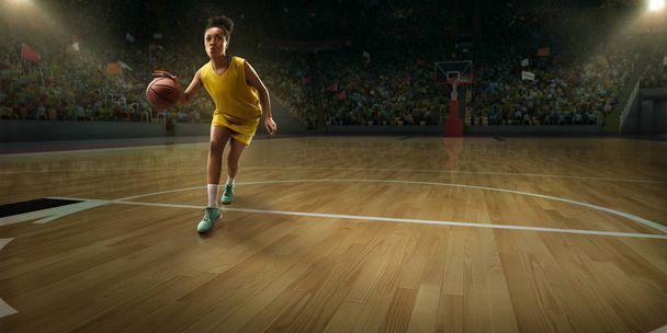 Jugadora de baloncesto femenina con balón en gran arena profesional
  - Foto, imagen