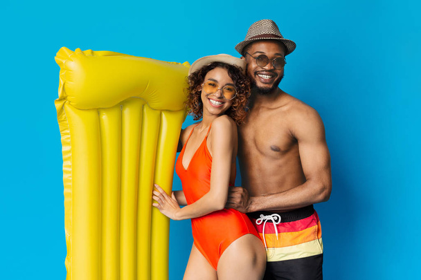 Happy black loving couple embracing with inflatable mattress - Photo, Image