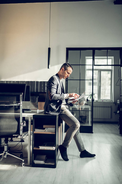 Stylish mature man working in the office and reading documents - Foto, Bild