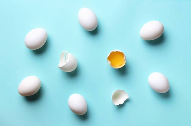 Concetto di cibo con uova bianche su sfondo blu. Vista dall'alto. Fantasia creativa in stile minimal. Posa piatta
 - Foto, immagini