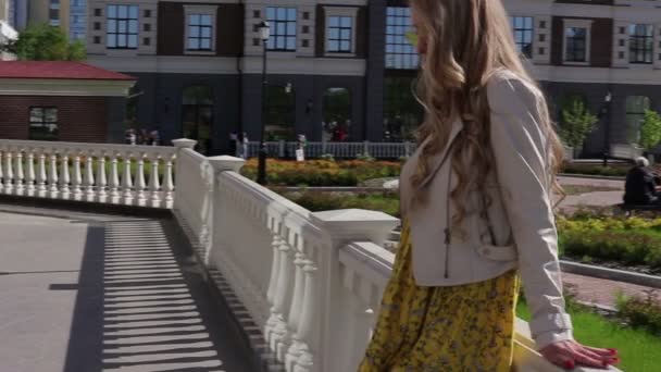 das stylische und attraktive Mädchen spaziert durch die Stadt entlang der Geschäfte - Filmmaterial, Video