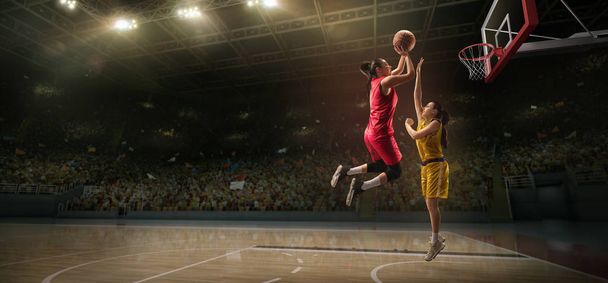 Las jugadoras pelean por el balón. Jugador de baloncesto hace slam dunk en gran arena profesional durante el juego
 - Foto, Imagen