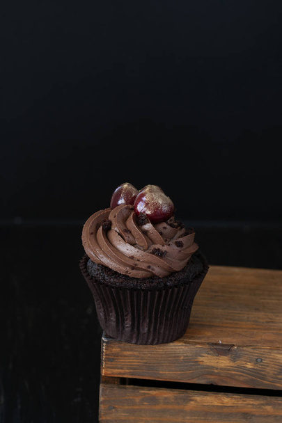 A tasty treat: a frosted cupcake with cherries on the top. - 写真・画像