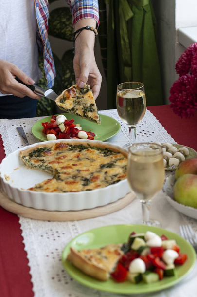 Um almoço gourmet: torta de espinafre com queijo, uma tigela de frutas, uma sa
 - Foto, Imagem