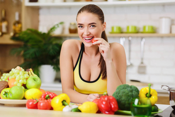 Здоровый образ жизни. Спортивная женщина стоит рядом с фруктами и овощами
 - Фото, изображение