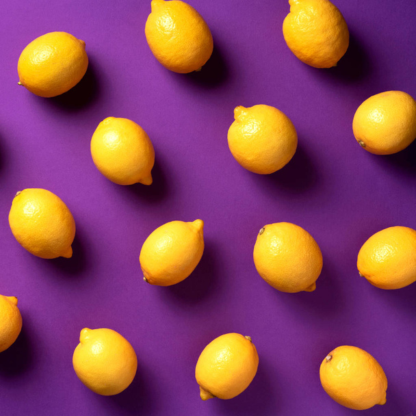Food pattern with lemons on violet paper background. Top view. Summer concept. Vegan and vegetarian diet. Square crop - Fotoğraf, Görsel