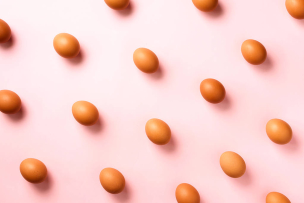 Food-Konzept mit Hühnereiern auf rosa Hintergrund. Ansicht von oben. kreative Muster im minimalistischen Stil. flache Lage. - Foto, Bild