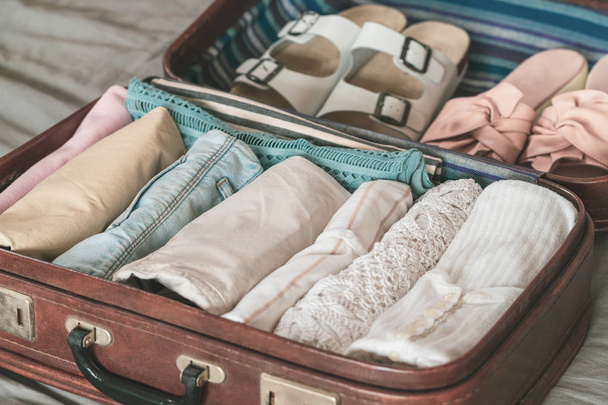 Открытая сумка с одеждой, аксессуарами и паспортом, концепция путешествий и отдыха
 - Фото, изображение