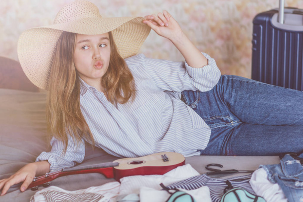Summer travel and vacation concept. Young woman packing suitcase at home - Foto, Imagem