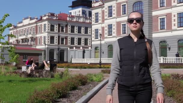Το κομψό και ελκυστικό κορίτσι περπατά μέσα από την πόλη κατά μήκος καταστήματα - Πλάνα, βίντεο