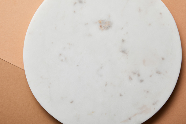 close up view of grey marble circle on beige and brown paper background - Foto, imagen