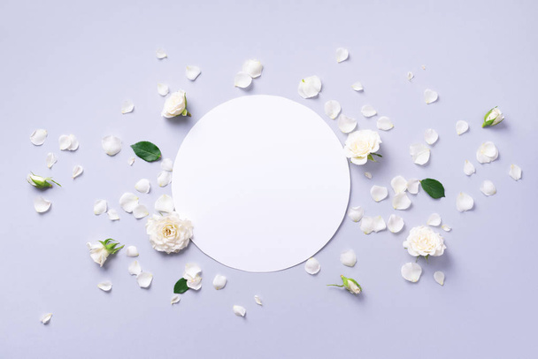 White rose flowers and petals on circle shape over grey background. Flat lay, top view. Creative layout. Spring or summer banner with copy space. Flowers composition. - Foto, imagen
