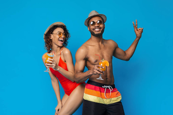 Happy millennial couple in swimwear drinking summer cocktails - Photo, Image