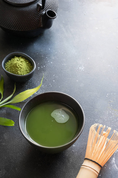 Organic green matcha tea in bowl on black table. Space for text. - Photo, image