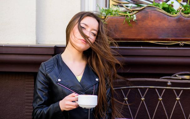 Девочке нравится утренний кофе. Женщина пьет кофе на улице. Мирный вдохновляющий момент. Девушка отдыхает в чашке капучино в кафе. Доза кофеина. Кофе для энергичного успешного дня. Время завтрака в кафе
 - Фото, изображение