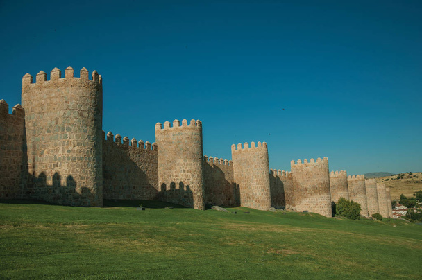 Stone towers on the large city wall and green lawn at Avila - Foto, Bild