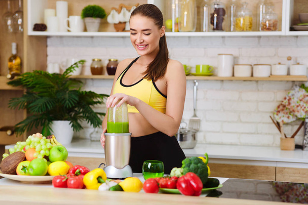 Woman Making Healthy Juice With Machine In Kitchen - Photo, Image