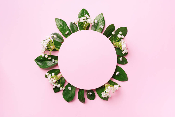 Creative layout made of green tropical leaves and white flowers on pink background. Top view. Flat lay. Summer or spring nature concept. Blank for advertising card or invitation. Mock up - Photo, image