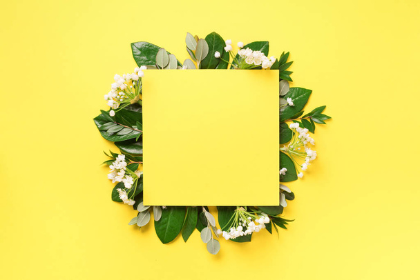 Summer and spring concept. Tropical nature background with green leaves, white flowers and white empty square frame for copy space on yellow paper. Top view. Flat lay. Creative advertising - Foto, Imagem