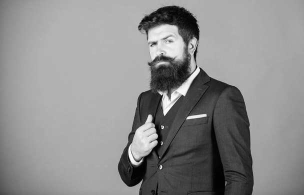 Businessman fashionable outfit stand violet background. Man bearded hipster wear classic suit outfit. Formal outfit. Elegancy and male style. Fashion concept. Guy wear formal outfit. Impeccable style - Photo, image