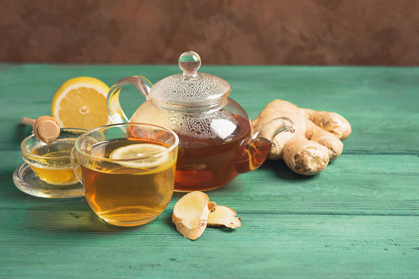 Tea lemon ginger with honey in a glass cup and a teapot on a wooden rustic background. Healthy drink for detox health. - Foto, Imagem