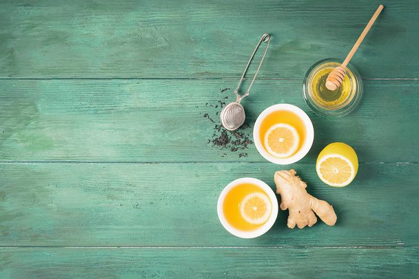 Чайний лимонний імбирний мед у білій чашці та дерев'яному фоні чайника. Здоровий напій для детоксикаційного здоров'я. Плоский вигляд зверху
. - Фото, зображення
