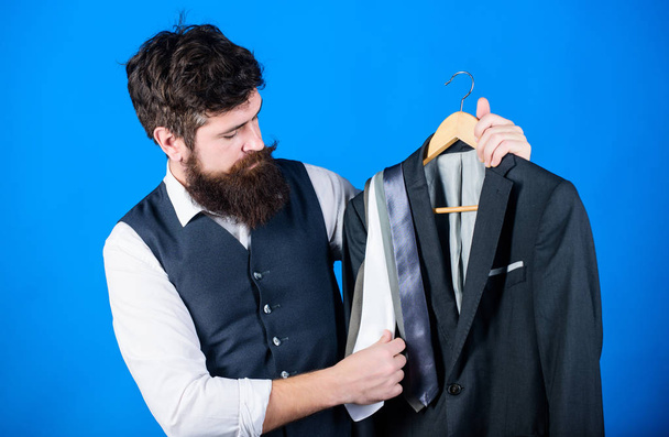 Difficulty choosing necktie. Shop assistant or personal stylist service. Matching necktie outfit. Man bearded hipster hold neckties and formal suit. Perfect necktie. Shopping concept. Stylist advice - Φωτογραφία, εικόνα