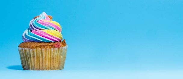 Colorful and enteresting cupcake isolated on blue background studio close up shot. - Foto, imagen