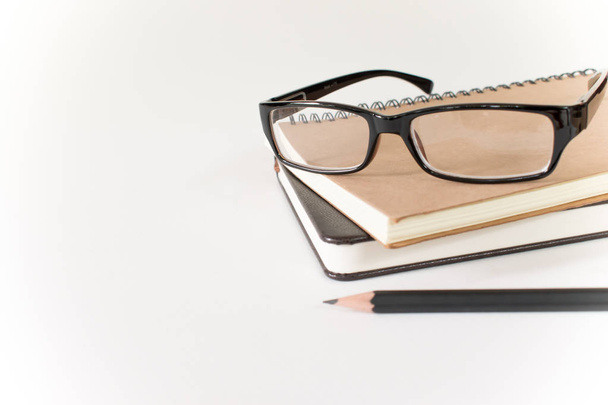 Gafas, libro y lápiz sobre fondo blanco
. - Foto, Imagen