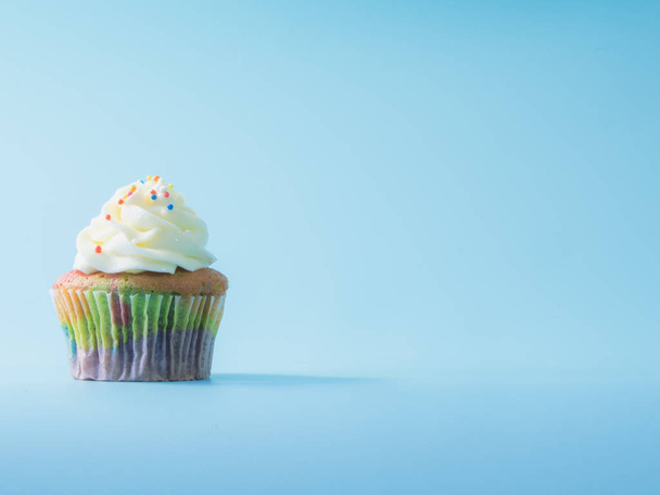 Colorful and enteresting cupcake isolated on blue background studio close up shot. - Zdjęcie, obraz