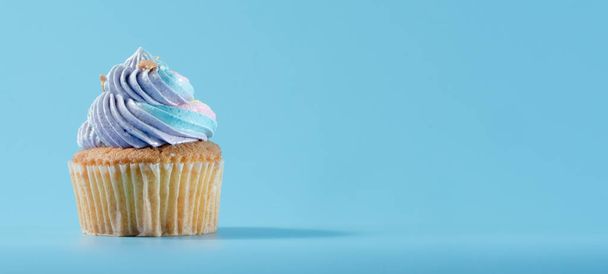 Kolorowe i enteresting Cupcake izolowane na niebieskim tle Studio z bliska strzał. - Zdjęcie, obraz
