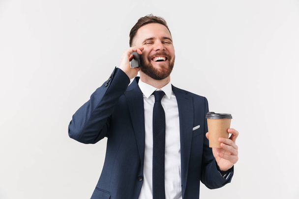 Happy businessman posing isolated over white wall background drinking coffee talking by phone. - Fotografie, Obrázek