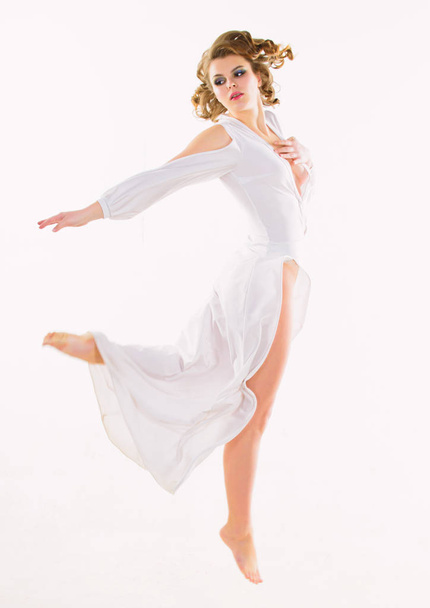 Tuntuu tuoreelta ja painottomalta. Tyttö houkutteleva vintage malli valkoisella taustalla. Nainen tyylikäs nainen retro kampaus meikki lentää tai hypätä valkoinen mekko. Seksikäs vintage muodikas mekko. Jumalallinen kauneus
 - Valokuva, kuva