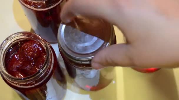Mujer pone mermelada de fresa hecha a mano en tarro
 - Imágenes, Vídeo