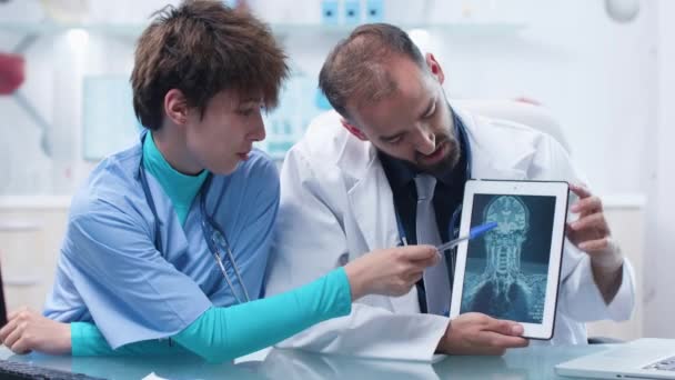 Lääkäri ja nuori sairaanhoitaja tarkastellaan MRI CT röntgenkuvaus digitaalinen tabletti PC
 - Materiaali, video