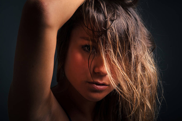 Dramatic woman close up portrait against black background. Filtered image. - Foto, Imagem
