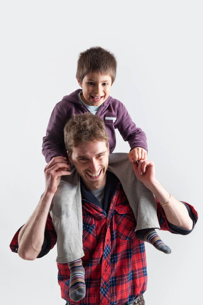 Young father and son playing together portrait. Studio shot - Photo, image