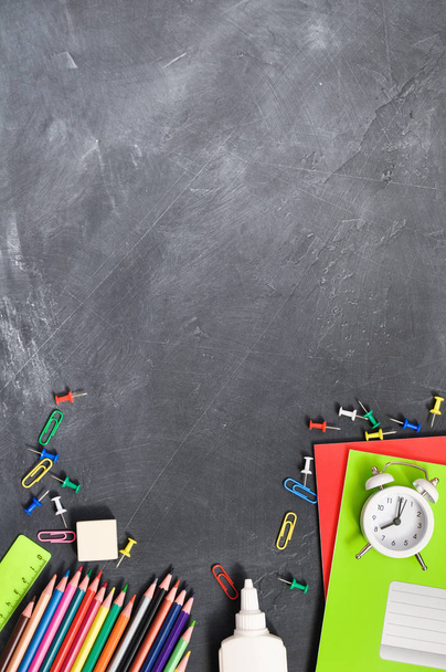 Bright stationery on a black Board background notebooks, pencils, scissors and others. Concept back to school - Foto, imagen