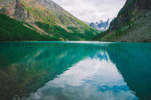 Shine water in Mountain Lake in Highlands. Prachtige gigantische besneeuwde bergen. Kreek stroomt van de gletsjer. Witte heldere sneeuw op de rug. Verbazingwekkende atmosferische landschap van majestueuze Altai natuur. - Foto, afbeelding