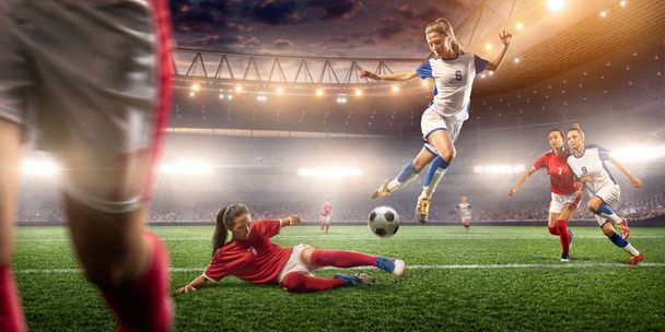 Οι γυναίκες παίκτες ποδοσφαίρου εκτελούν ένα παιχνίδι δράσης σε ένα επαγγελματικό γήπεδο ποδοσφαίρου. Κορίτσια παίζουν ποδόσφαιρο - Φωτογραφία, εικόνα
