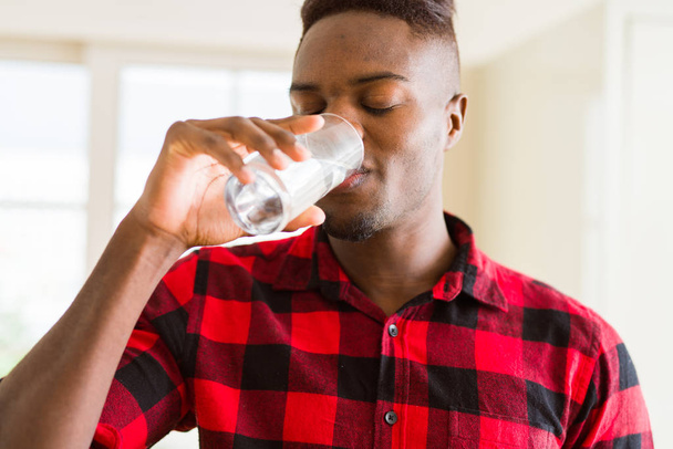 Jonge Afro-Amerikaanse man een vers glas water drinken - Foto, afbeelding