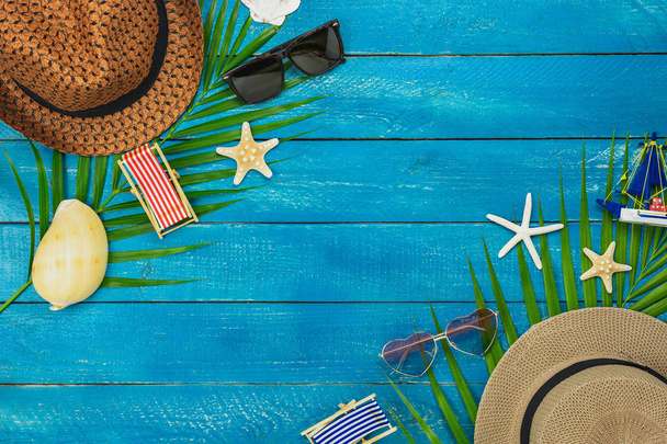 Table top view accessory of clothing women & men  plan to travel in summer holiday background concept.hat with many essential items sunglasses & hat on modern rustic blue wooden.Space for design. - Photo, Image