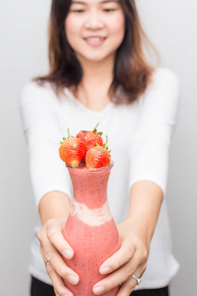 Cheirando asiático mulheres com morango fruta smoothie garrafa
 - Foto, Imagem