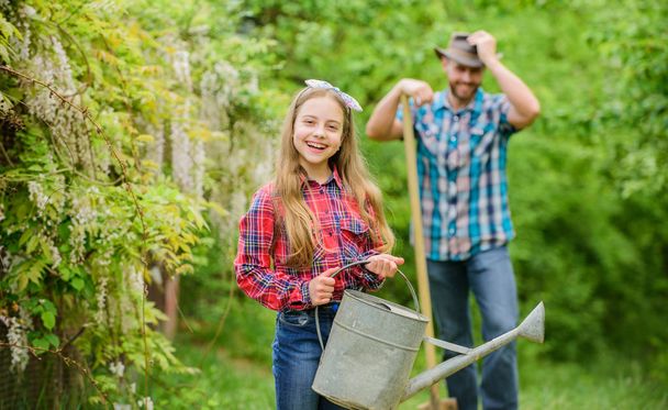 ecology. Watering can and shovel. spring village country. family farm. little girl and happy man dad. earth day. father and daughter on ranch. Working with pleasure. Flowers presentation - Photo, image