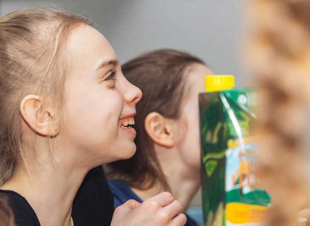 Happy young girl sitting near a package of juice - Foto, immagini