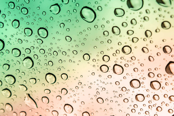 gekleurde regendruppels op glas  - Foto, afbeelding