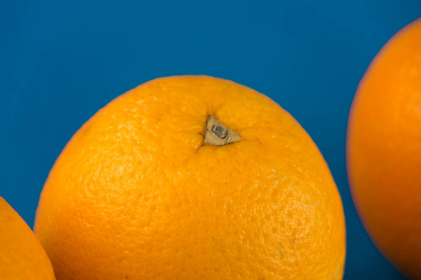 Κοντινά πλάνα από ένα ζωηρό πορτοκαλί πορτοκαλί αίμα στο γαλάζιο φόντο με χώρο αντιγραφής - Φωτογραφία, εικόνα