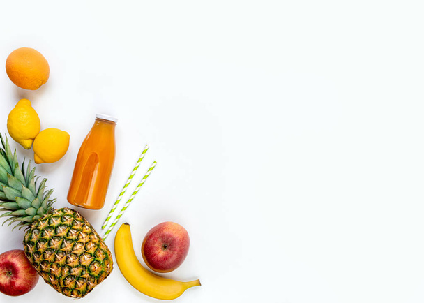 Top view of various fruits and a bottle of freshly squeezed  multivitamin juice on a white background. Copy space. Flat lay. - Φωτογραφία, εικόνα